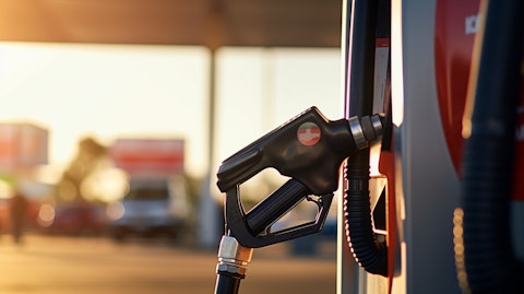 A close-up of a gasoline pump nozzle at a service station, revealing the company's consumer-facing branding.