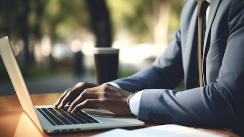 A businessperson in business attire writing a job post on their laptop.