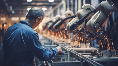An engineer adjusting a robotic arm in a factory line to control engineered air movement solutions.