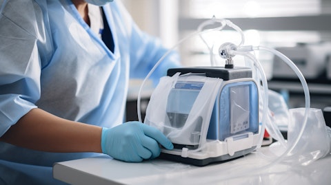 A close-up of a medical technician wearing lab coat and a face mask preparing a portable oxygen concentrator for a patient.
