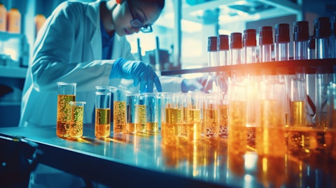 A pharmaceutical scientist in a lab working with a microscope, with brightly colored liquid samples in the background.