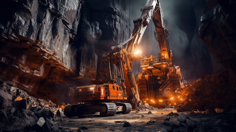 A large drill in operation deep in a mine, surrounded by the machinery of a modern extraction site.