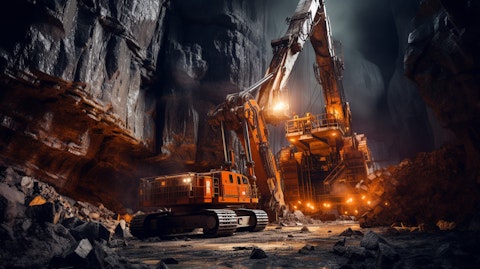 A large drill in operation deep in a mine, surrounded by the machinery of a modern extraction site.