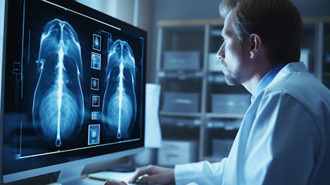 A radiologist studying a monitor with a detailed image of a lung cancer tumor.
