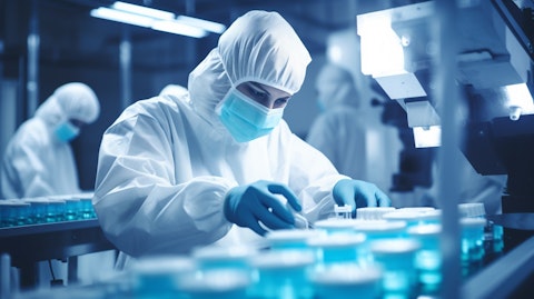 A laboratory technician processing a batch of medication in an industrial setting.