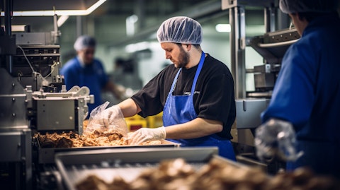 A worker taking out freshly made packaged food products from a production line.