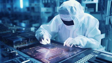 An engineer in a cleanroom testing and tweaking an integrated circuit.