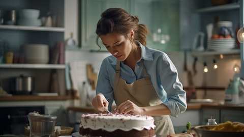 A female baker in a spotless kitchen carefully decorating a cake.
