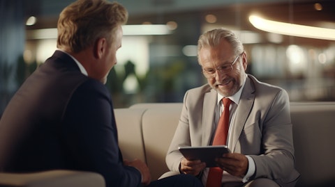 A wealth manager holding a tablet, talking to a client in an authoritative setting, highlighting the trust services the company offers.