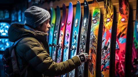 A close-up image of a shopper examining a colorful snowboard on a retail store rack.