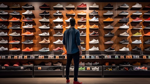 A shopper browsing the wide selection of trendy footwear in a franchised store.