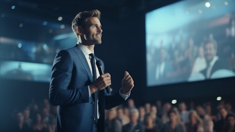 A CEO in a suit making a keynote speech in a modern tech conference.