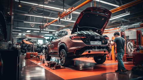 A busy auto service bay with technicians servicing a car.