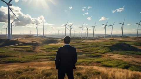 An energy executive observing a wind turbine farm from a remote location.