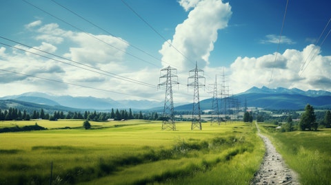 A view of the power lines passing through the landscape pointing towards a distant industrial facility.