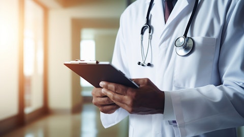 A healthcare professional using an iPad to help a patient intake process.