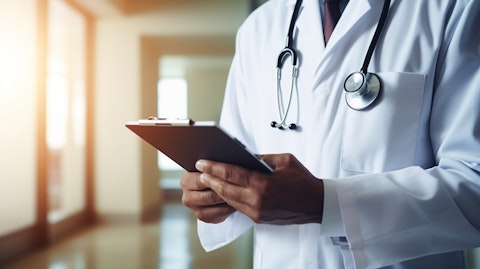 A healthcare professional using an iPad to help a patient intake process.