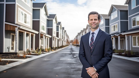 A real estate executive standing in front of a row of newly constructed townhomes.