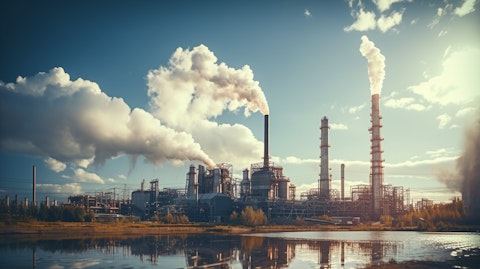 An industrial oil and gas plant, with stacks of pipes issuing steam into the sky.