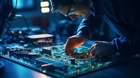 An engineer manipulating a complex circuit board that will be used in flat panel displays.