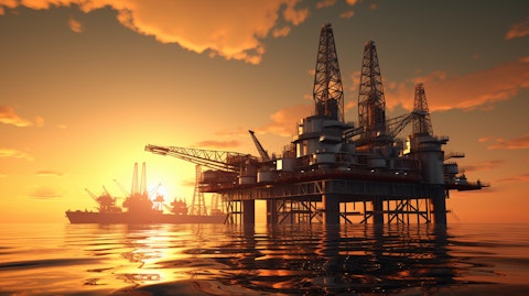 An oil rig platform at sea, surrounded by a golden sunrise.