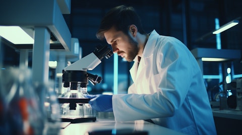 An experienced scientist studying a microscope in a laboratory, researching antibody-based therapeutics.
