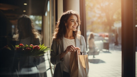 A smiling woman walking out of a franchised store, her new purchase in her arm.