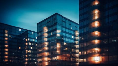 A row of hotel buildings illuminated at night revealing the companies hospitality arm.