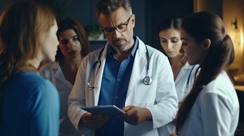 A doctor in scrubs discussing a patient's test results with a small group of concerned family members.