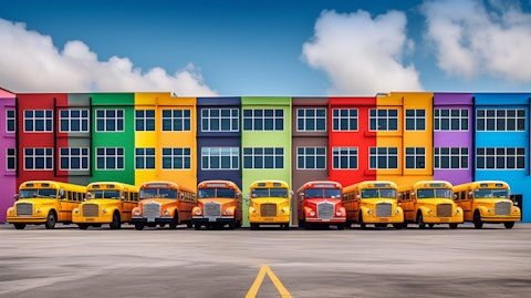 A group of school buses lined up in front of a large building, painted in bright colors.