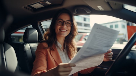 A woman in her car checking her insurance documents with a satisfied smile.
