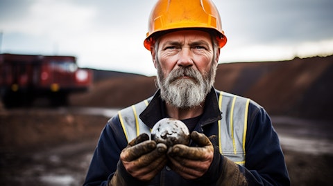 A miner in a hard hat and apron holding a piece of uranium ore in the Athabasca Basin, Saskatchewan.