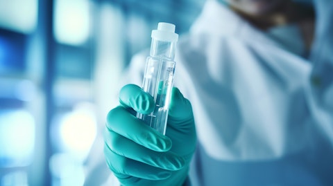 A lab worker holding a vial of biopharmaceuticals for cellular therapies.
