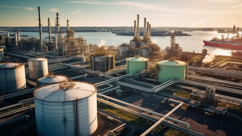 A bird's eye view of an industrial refinery, with petrochemical tanks and pipes in the background.