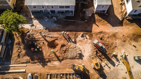 An aerial view of a residential construction project with workers and machinery at work.