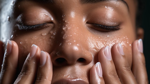 A close-up of a woman's hands while applying a facial cleansing product.