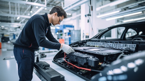 An engineer examining an electric vehicle design in a lab, showing the company's innovative battery systems.
