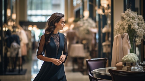 A well dressed woman in a beautiful dress walking into an upscale apparel boutique.