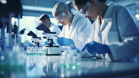 A team of biopharmaceutical researchers in white lab coats working in a laboratory.