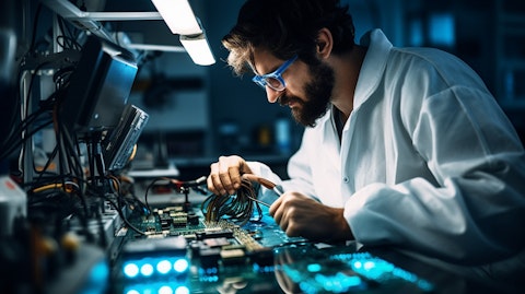 A technician in a lab coat soldering chipsets to power the company's infotainment head units.