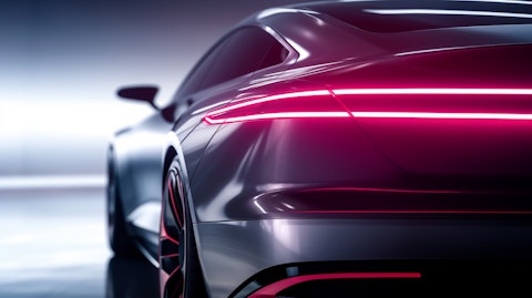 A close-up of a luxury electric sports sedan, its sleek body reflecting the energy of progress.