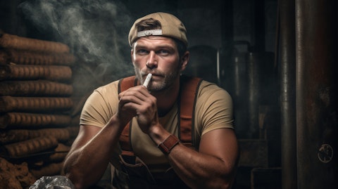 A worker athlete with a rolling paper held in hand, smoking from the finished cigar.