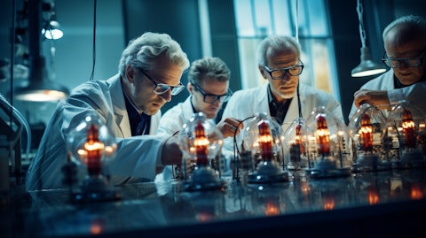 A team of scientists in a laboratory environment, examining precision resistors and strain gages.