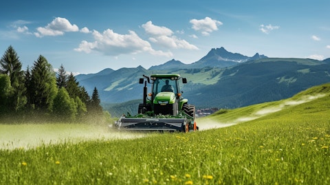 A tractor-mounted mower cutting through a lush green meadow.