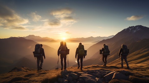 A group of hikers on a isolated mountain range with a clear sunset in the background.