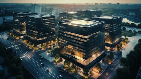 Aerial view of a large REIT building complex, its facade reflecting the city skyline.