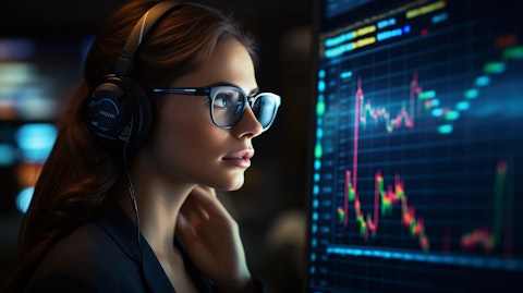 A data analyst with a headset, looking intently at the information unfolding on her screen.