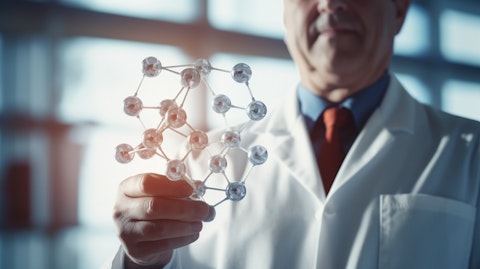 A physician holding a molecule model to explain the use of a therapy for primary immunodeficiencies.