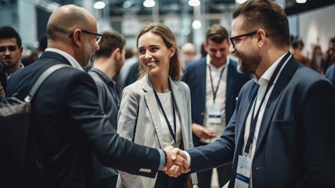 A group of smiling job seekers shaking hands with employers at a job fair.