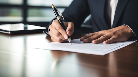 A business executive signing a contract for a workers compensation policy at an office desk.